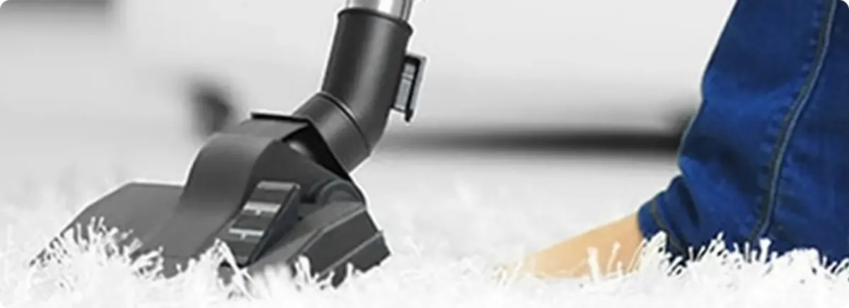 Close-up of a professional vacuuming a white carpet in Golden.